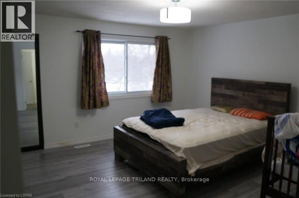 A bedroom with a bed, curtains, and a window.