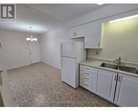 A kitchen with white cabinets and a white refrigerator.