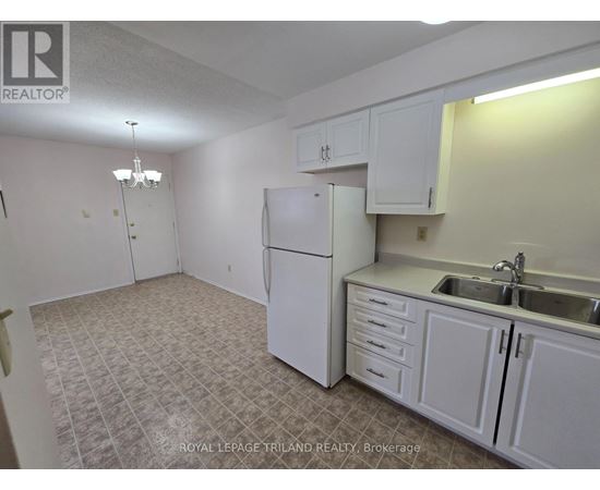 A kitchen with white cabinets and a white refrigerator.