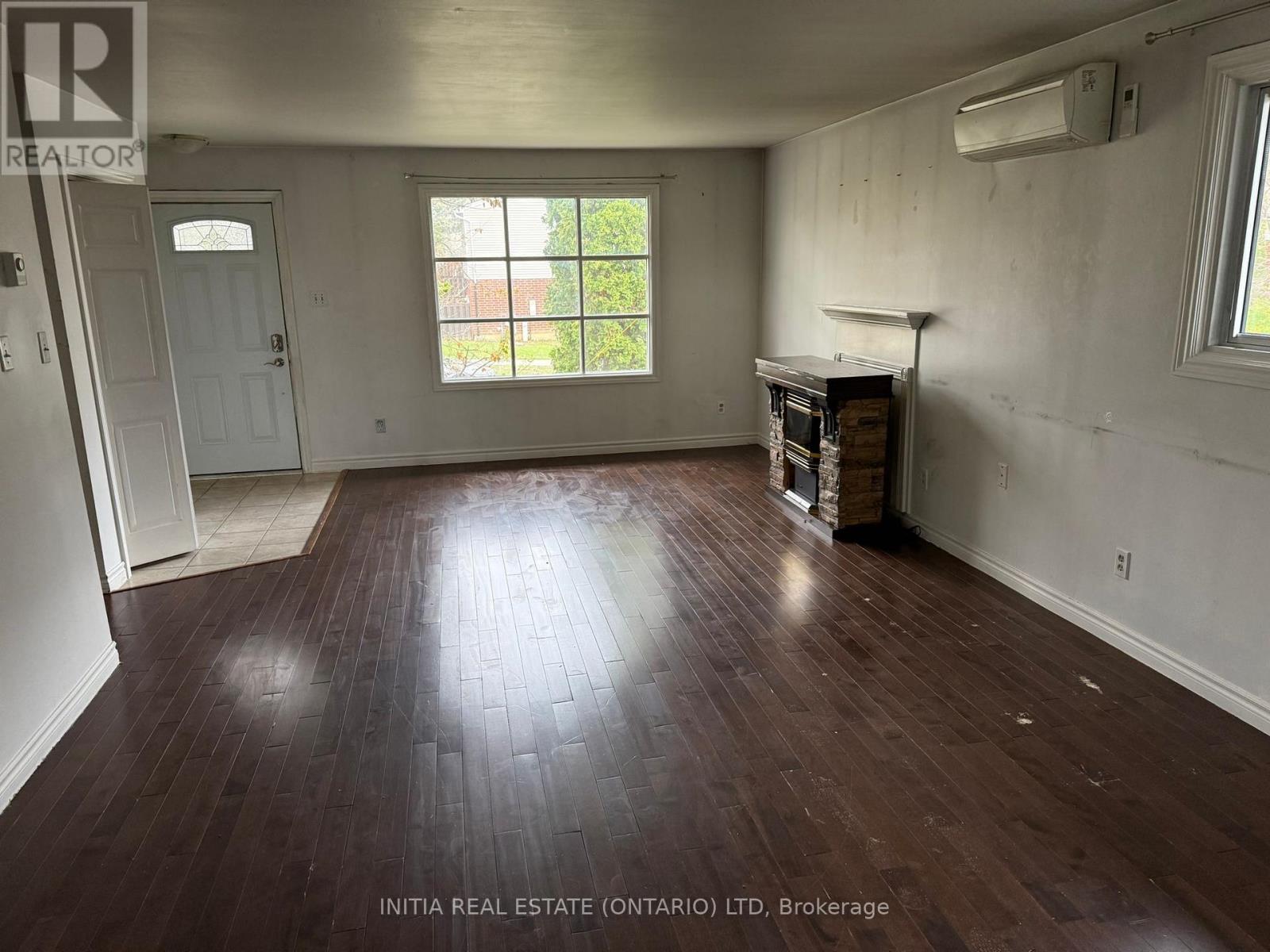A room with wood flooring and a window letting in light.