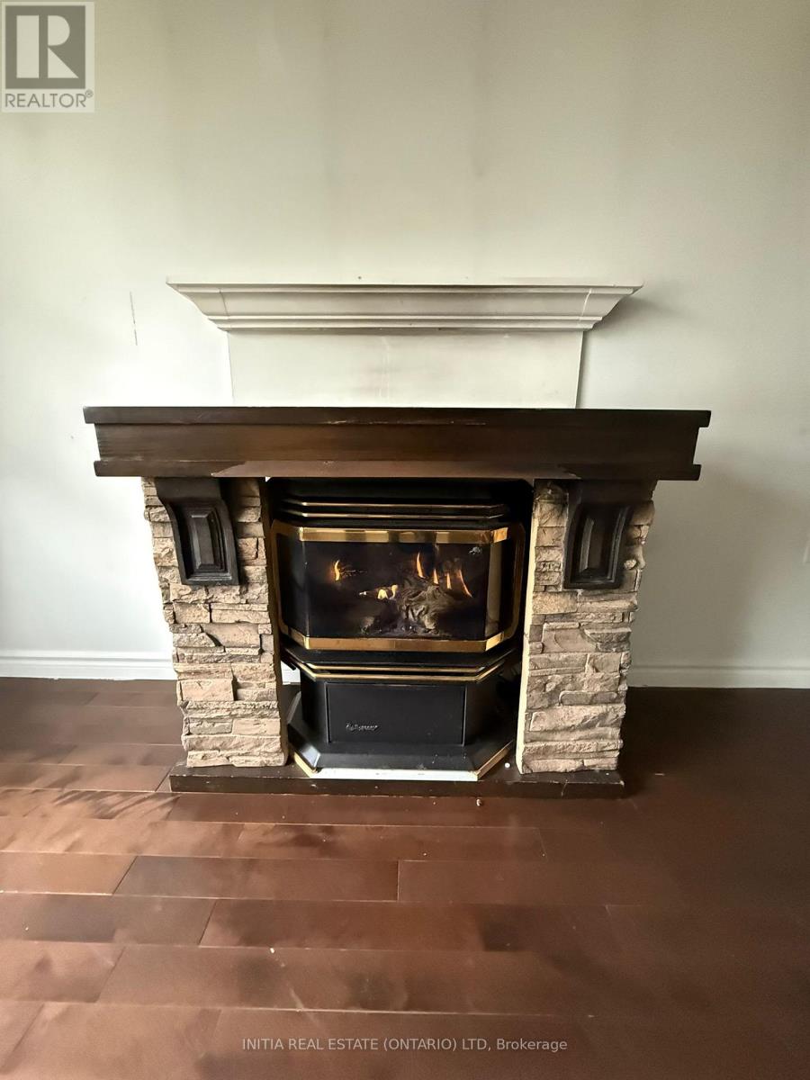 A fireplace with a stone surround and a wooden mantle.