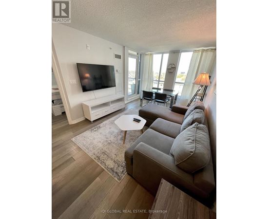 A living room with a grey couch and a white entertainment unit.