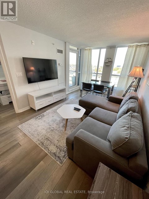 A living room with a grey couch and a white entertainment unit.