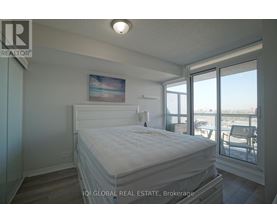 A bedroom with a large bed and a view of the outside through the window.