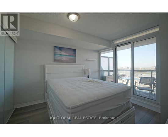 A bedroom with a large bed and a view of the outside through the window.