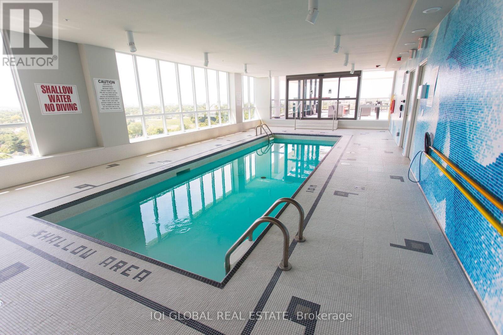 A large indoor swimming pool with a sign that says shallow area.