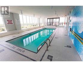 A large indoor swimming pool with a sign that says shallow area.