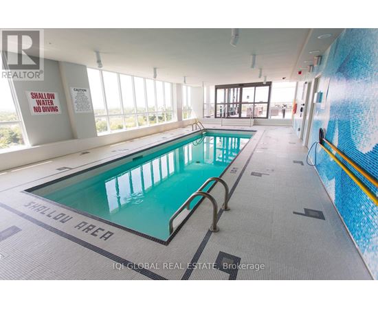 A large indoor swimming pool with a sign that says shallow area.