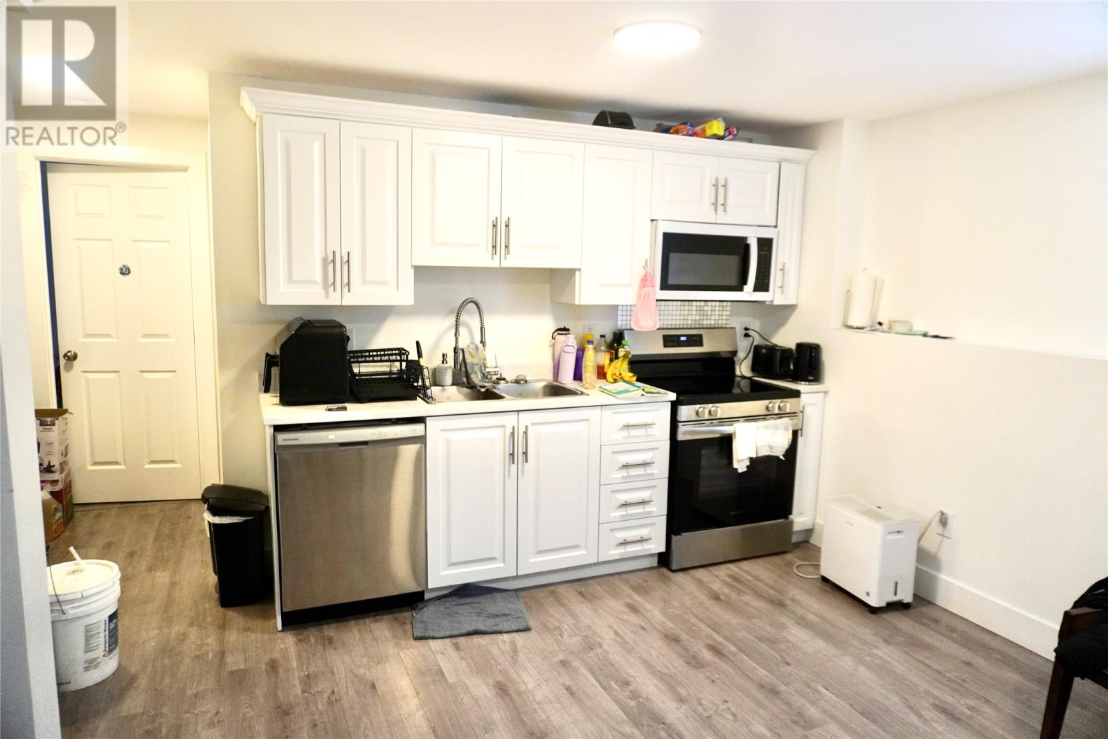 A kitchen with white cabinets and stainless steel appliances.