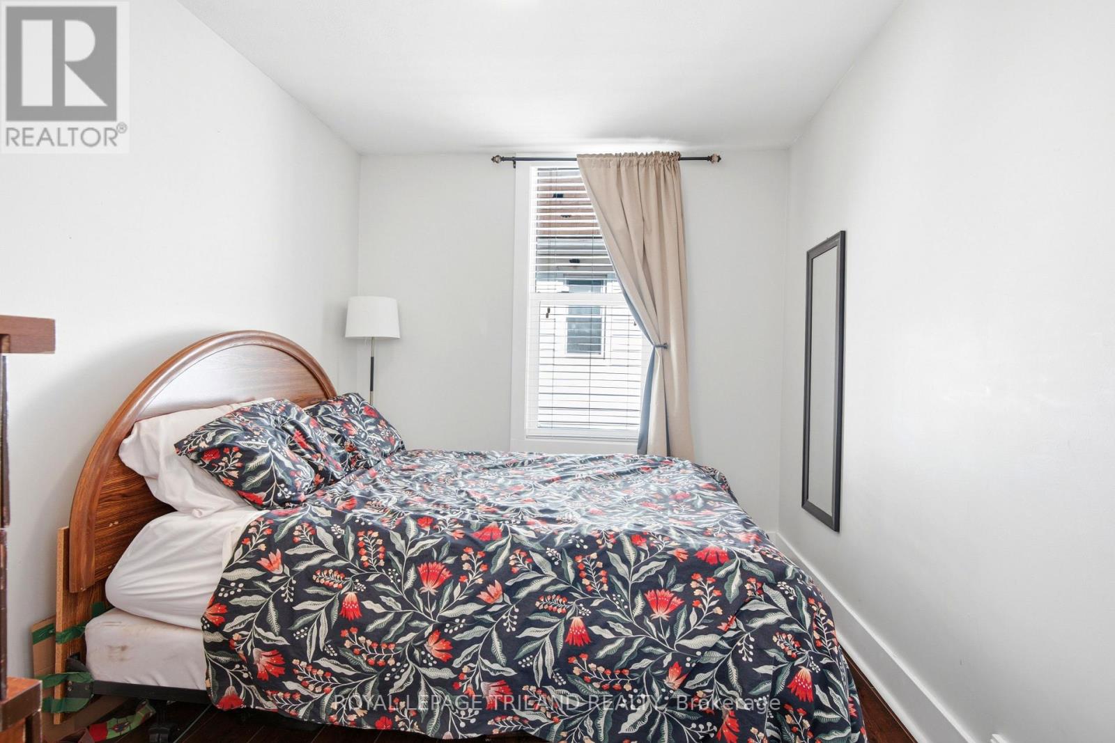 A bedroom with a bed covered in a floral print bedspread.