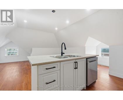 A kitchen with a sink and a refrigerator.