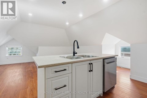 A kitchen with a sink and a refrigerator.