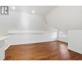 A room with wooden flooring and white walls.
