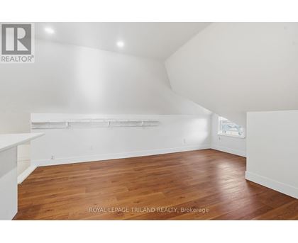 A room with wooden flooring and white walls.