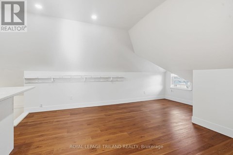 A room with wooden flooring and white walls.