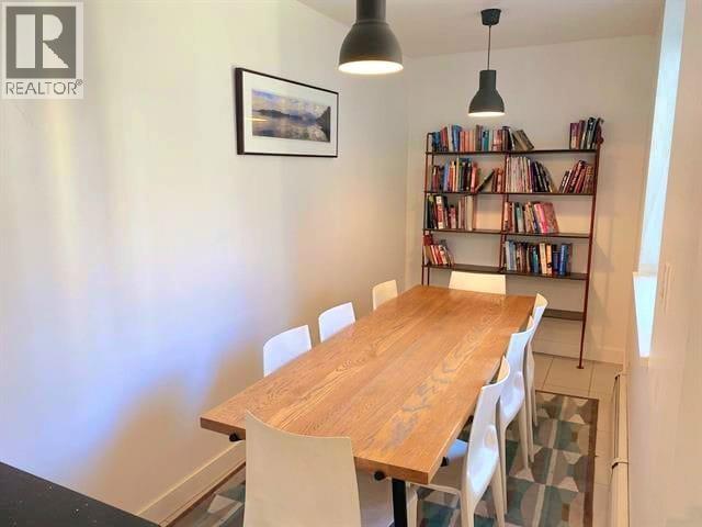 A dining room with a wooden table and chairs.