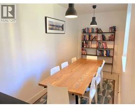A dining room with a wooden table and chairs.