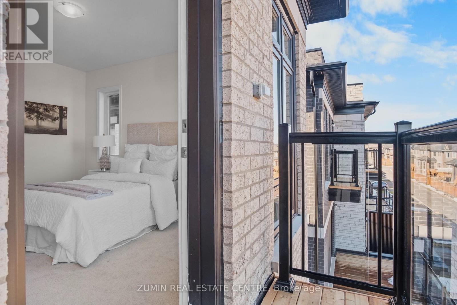 A bedroom with two beds and a balcony overlooking a cityscape.