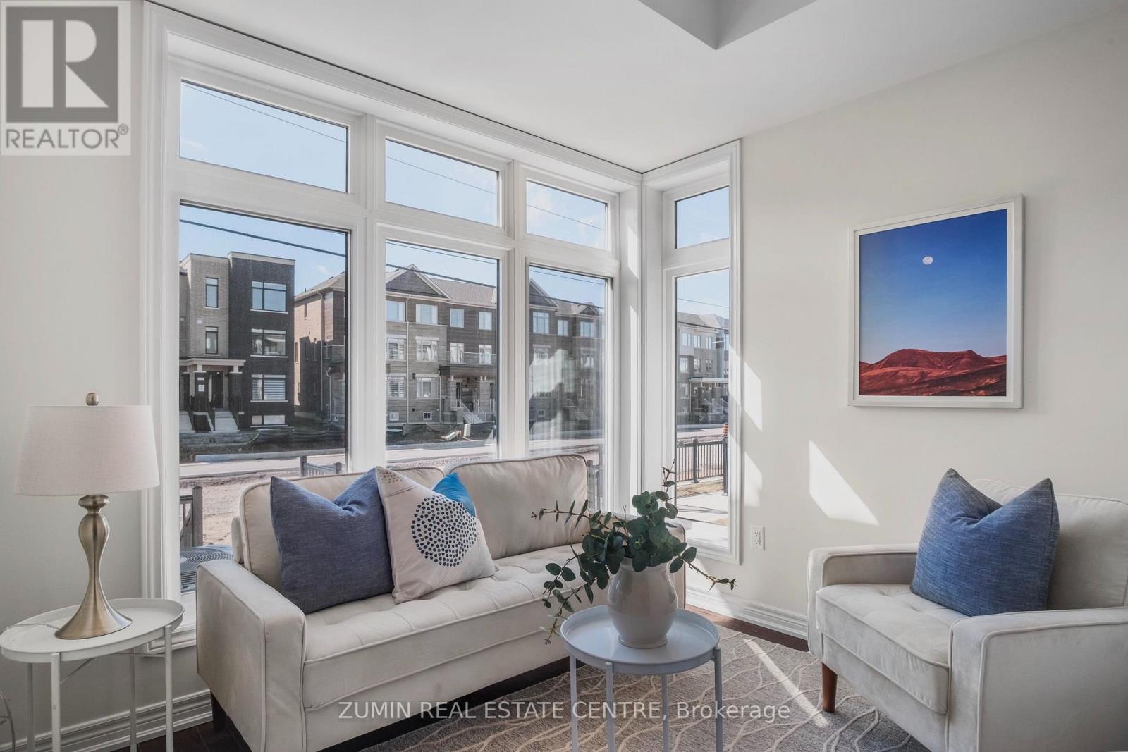 A living room with a couch, a table, and a painting on the wall.