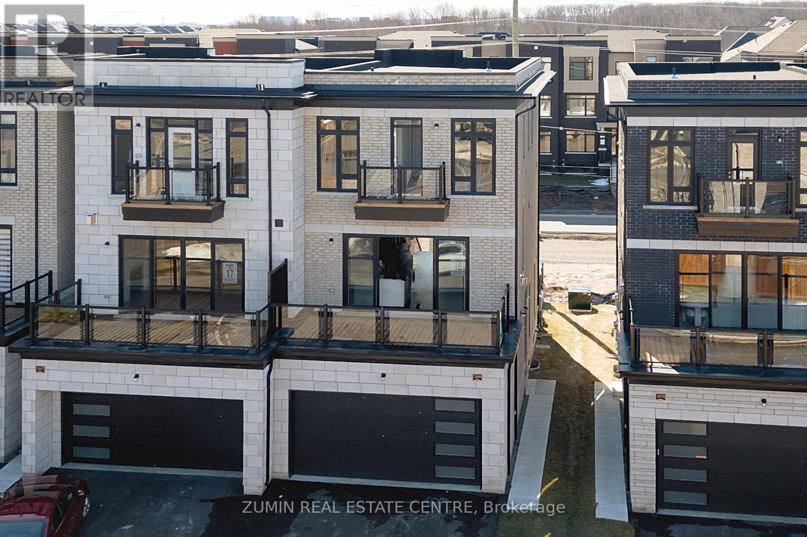 A row of modern townhouses with balconies and garages.