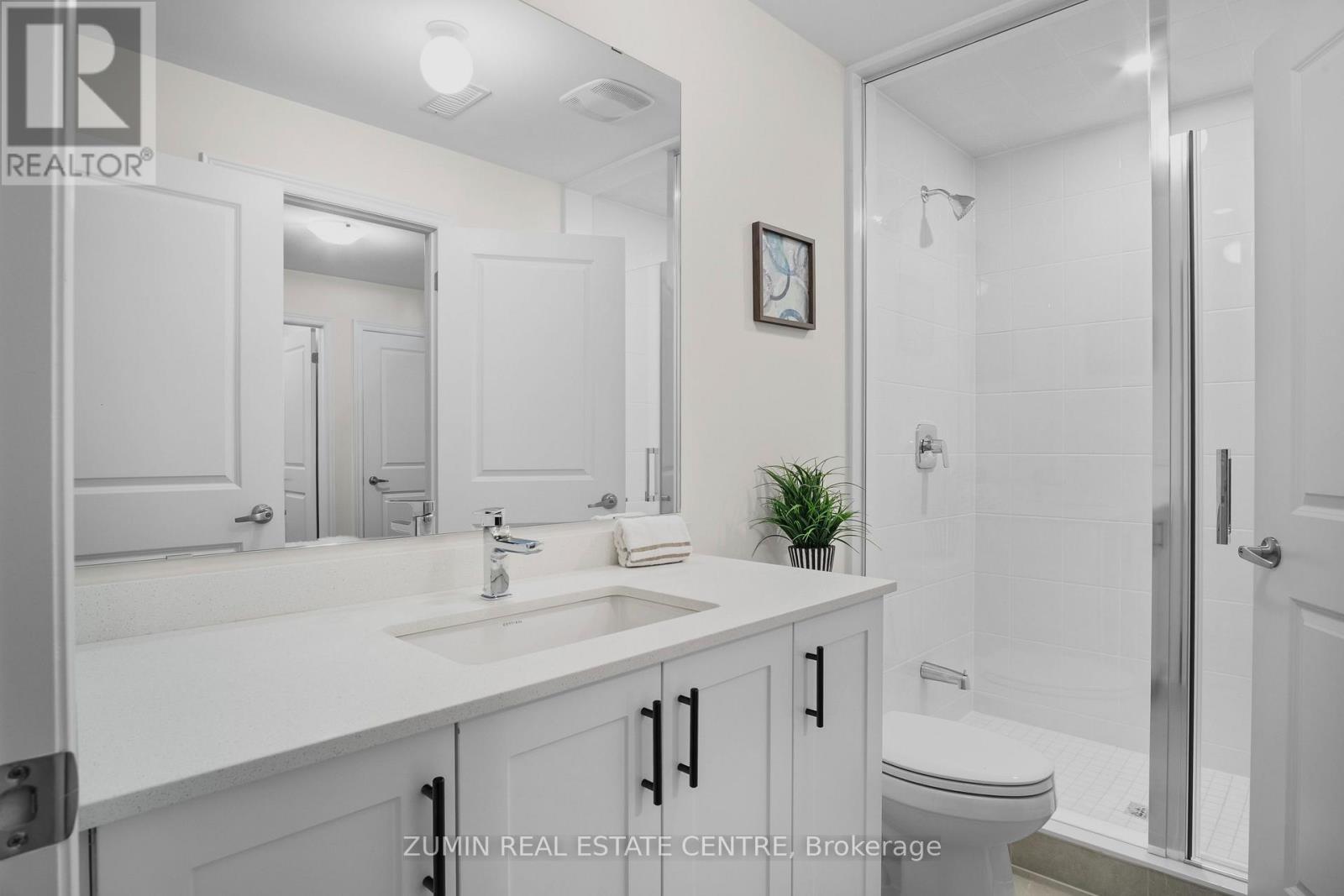 A bathroom with a sink, toilet, and mirror.