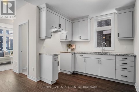 A kitchen with white cabinets and a marble countertop.