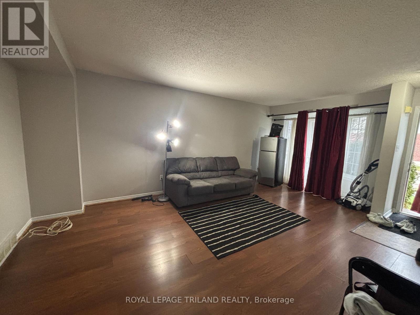 A living room with a grey couch and a striped rug.