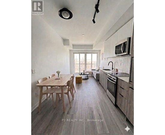 A modern kitchen with wooden floors and a dining table.