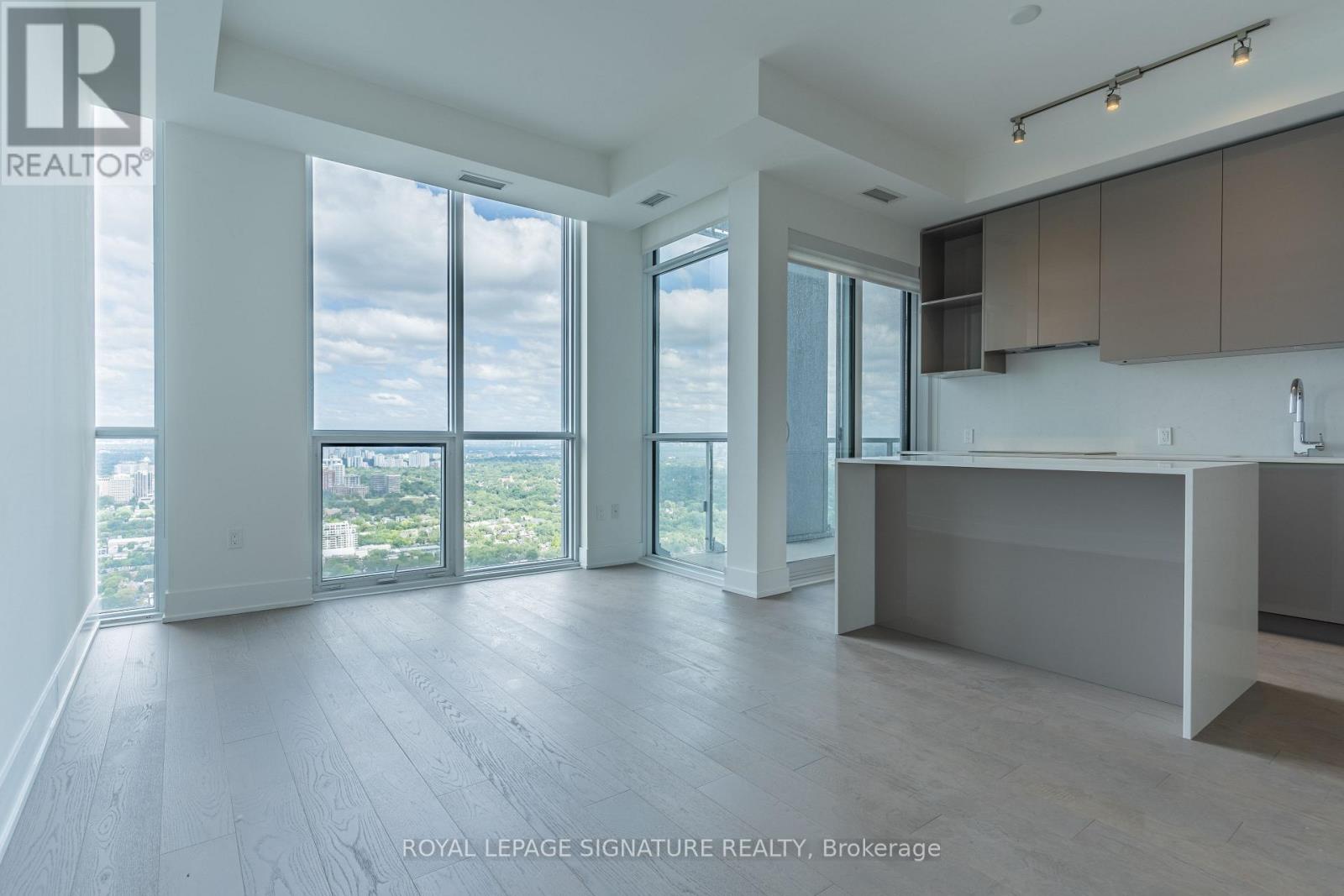 A spacious, empty room with a large window overlooking a cityscape.