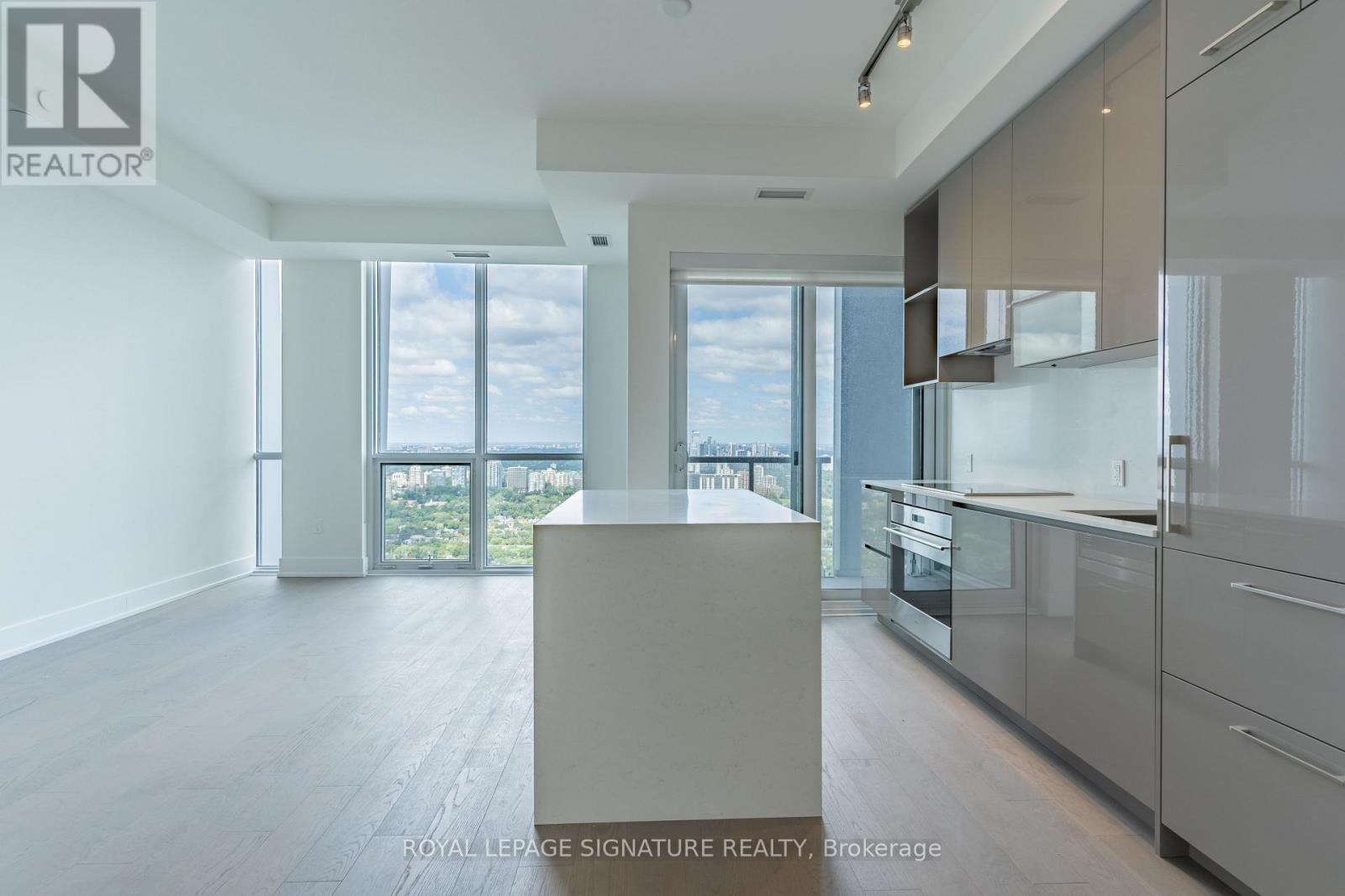 A spacious kitchen with a view of the city through the windows.
