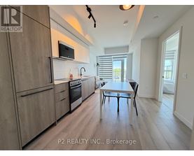 A modern kitchen with wooden cabinets and a dining table.