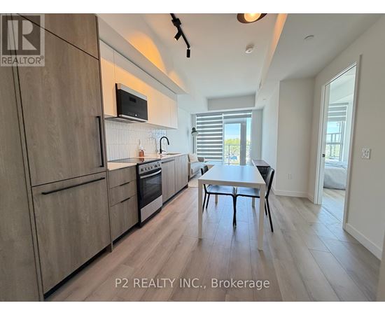 A modern kitchen with wooden cabinets and a dining table.