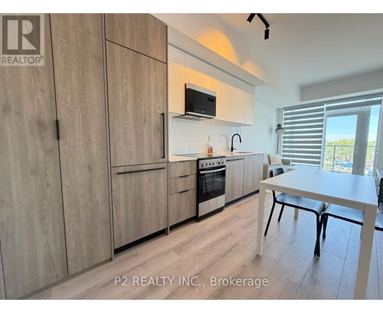 A kitchen with wooden cabinets and a white table.