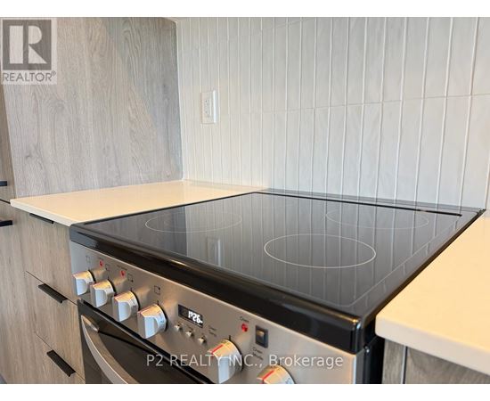 A modern kitchen with a stove top oven and wooden cabinets.