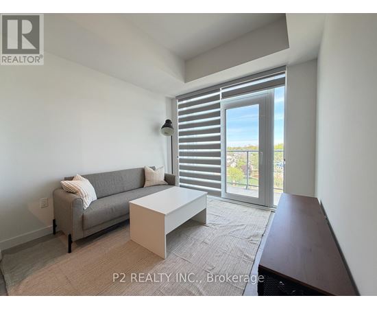 A living room with a grey couch and a white coffee table.