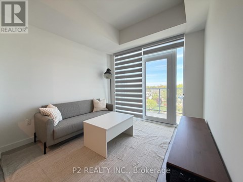 A living room with a grey couch and a white coffee table.