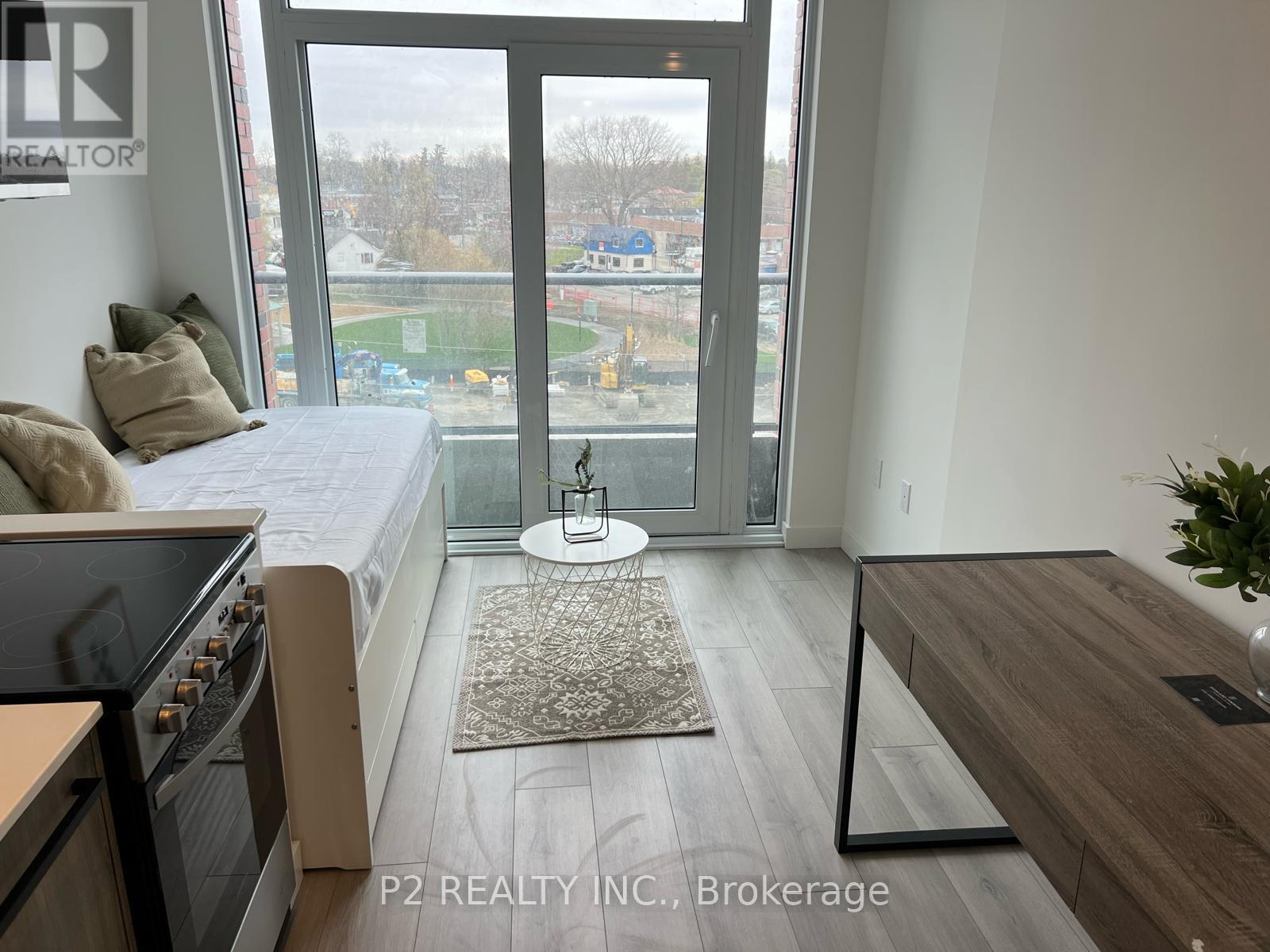 A bedroom with a large bed and a view of a parking lot through the window.
