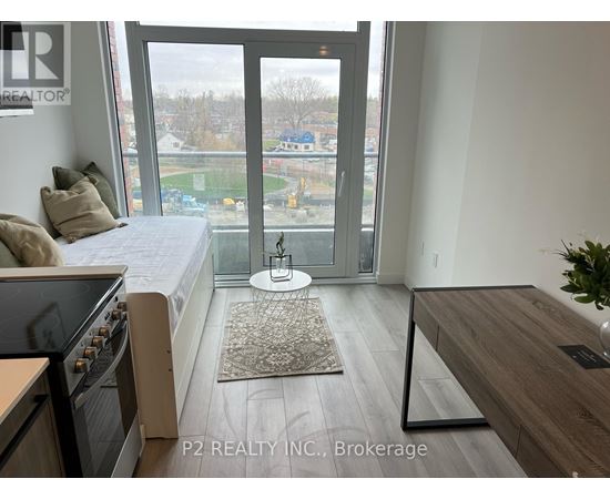 A bedroom with a large bed and a view of a parking lot through the window.