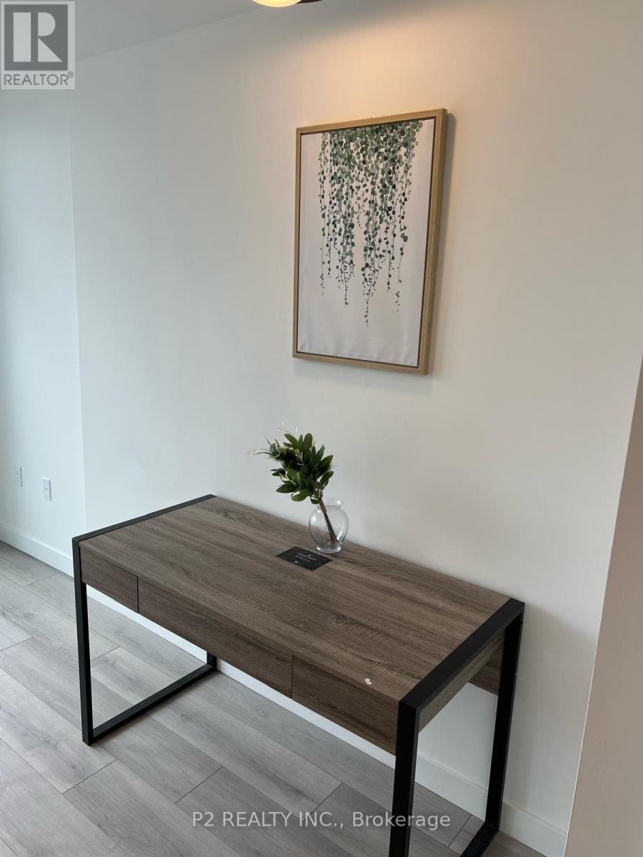 A table with a plant on it and a picture on the wall.