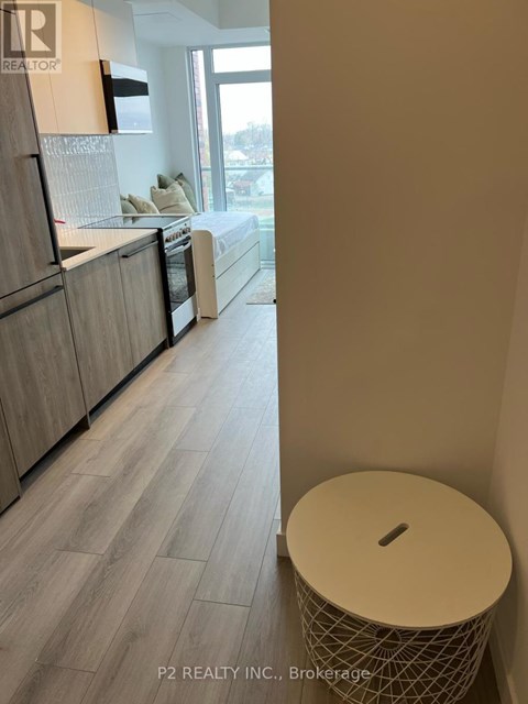 A modern kitchen with wooden cabinets and a large window.