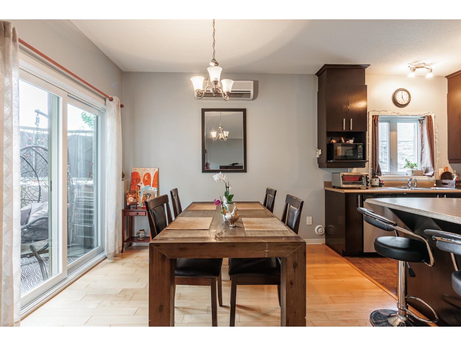 A dining room with a wooden table and chairs.