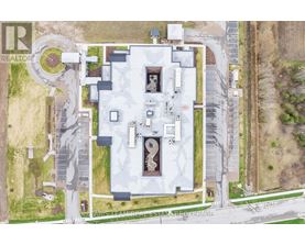 A large white building with a circular driveway in front of it.