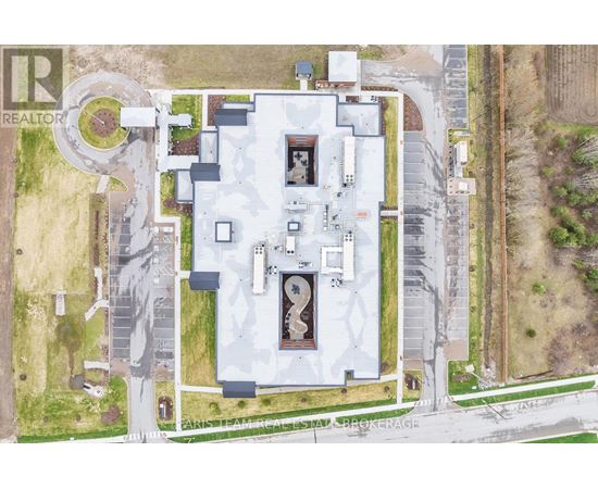 A large white building with a circular driveway in front of it.