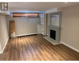 A room with a fireplace and wooden flooring.