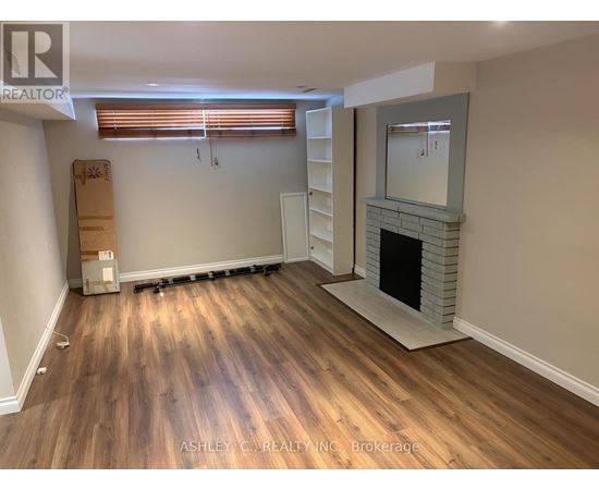 A room with a fireplace and wooden flooring.
