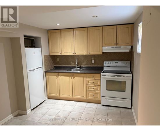 A kitchen with a white refrigerator, brown cabinets, and a white stove top oven.