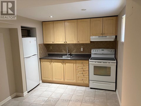 A kitchen with a white refrigerator, brown cabinets, and a white stove top oven.