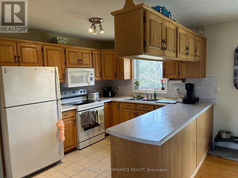 A kitchen with wooden cabinets and a white refrigerator.