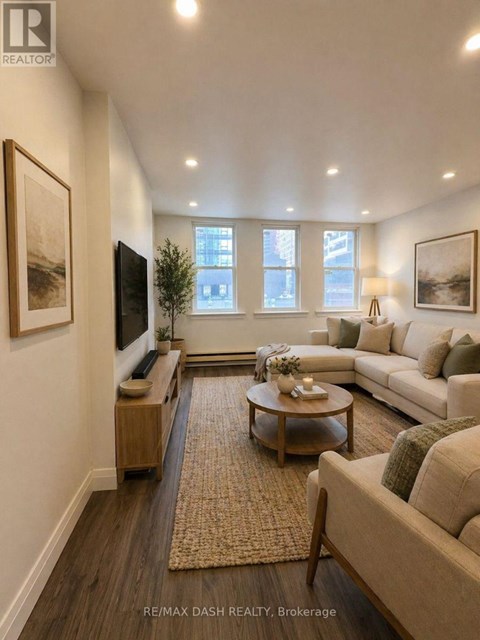 A living room with a couch, coffee table, and a flat screen TV.