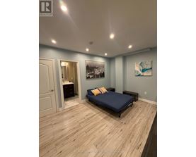 A bedroom with a bed, dresser, and a painting on the wall.